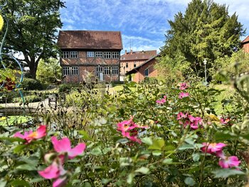 Foto vom Königin Christinenhaus. Im Vordergrund Blumen 