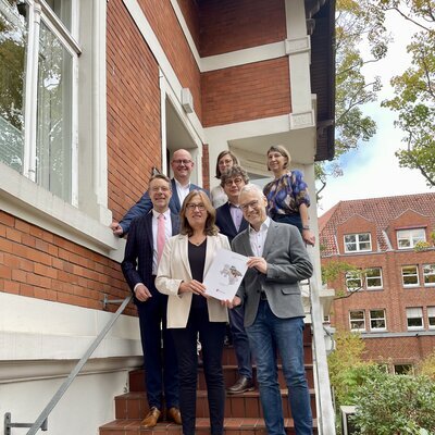 Karin Beckmann (ArL Lüneburg) überreicht die Mittelteilung zum Programmjahr 2025 der Stadt Zeven an Bürgermeister Jens Petersen und Stadtdirektor Henning Fricke