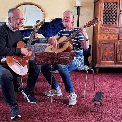 Zwei fröhliche Gitarrenspieler während der Zevener Gitarrenwoche 